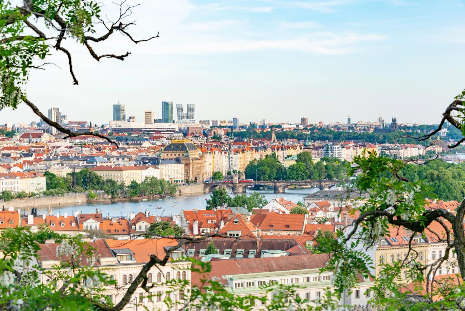 A beautiful aerial shot of Prague showcasing historic architecture and lush greenery along the Vltava River