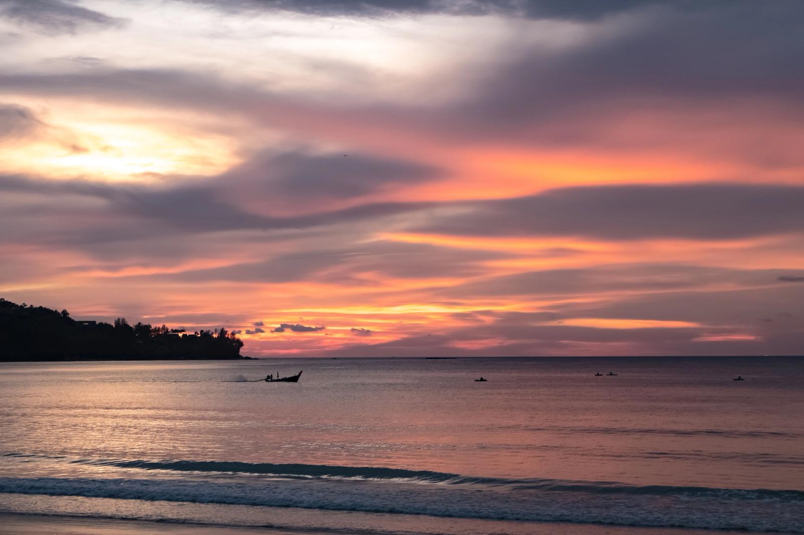 Beautiful sunset over the sea in Phuket, Thailand with colorful clouds and calm water