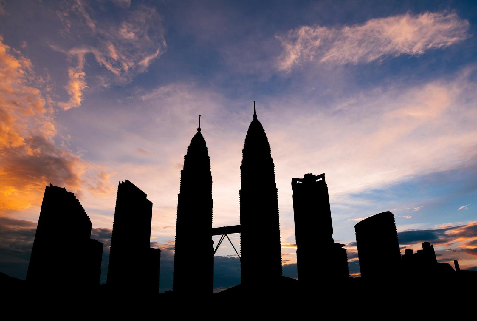 Stunning silhouette of Kuala Lumpur's Petronas Towers against a vibrant sunset sky