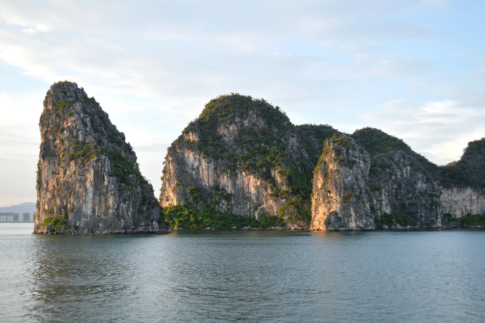 Scenic view of iconic limestone cliffs reflecting in the ocean at Halong Bay, Vietnam