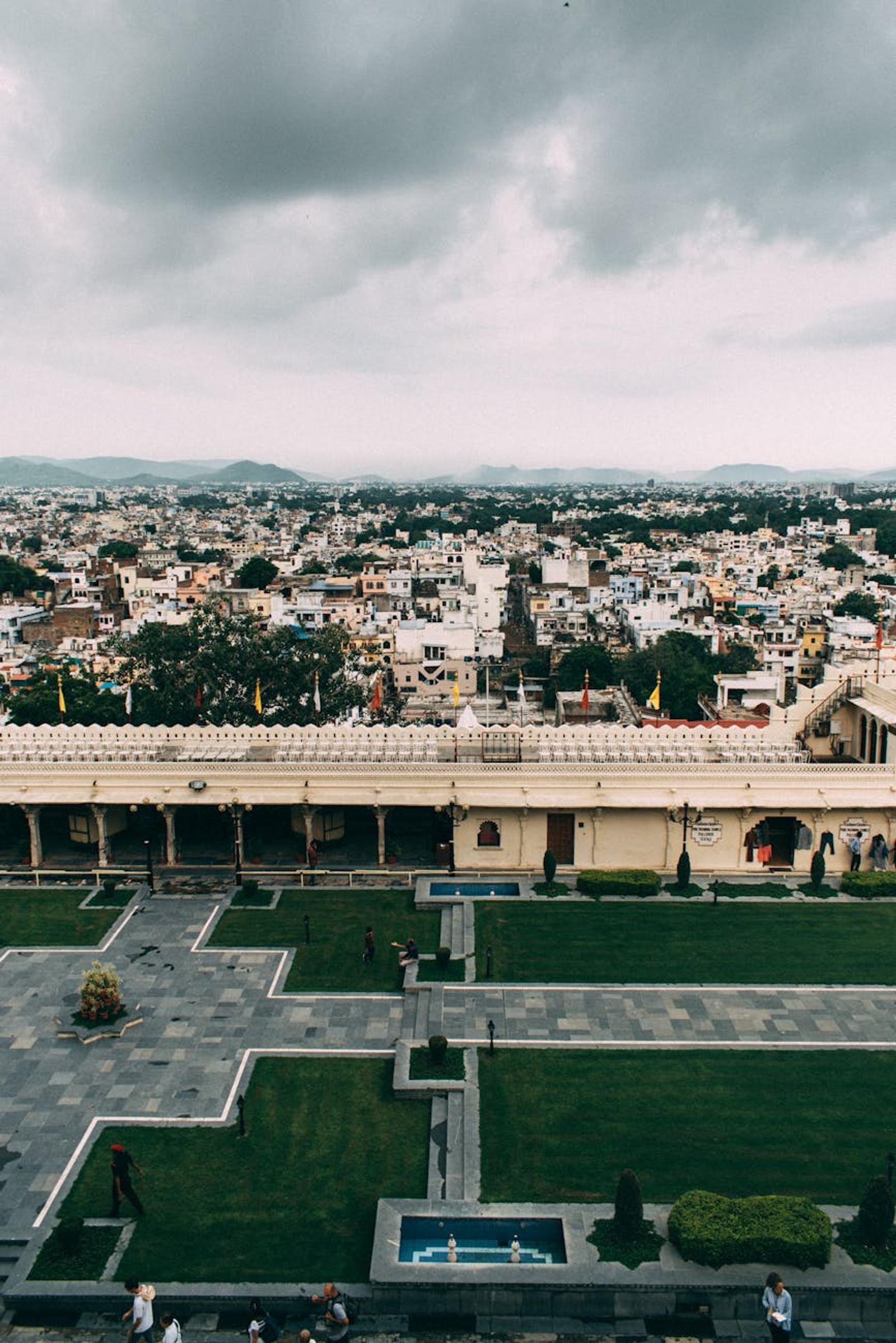 Stunning aerial shot capturing Udaipur's architecture and lush courtyards under overcast skies