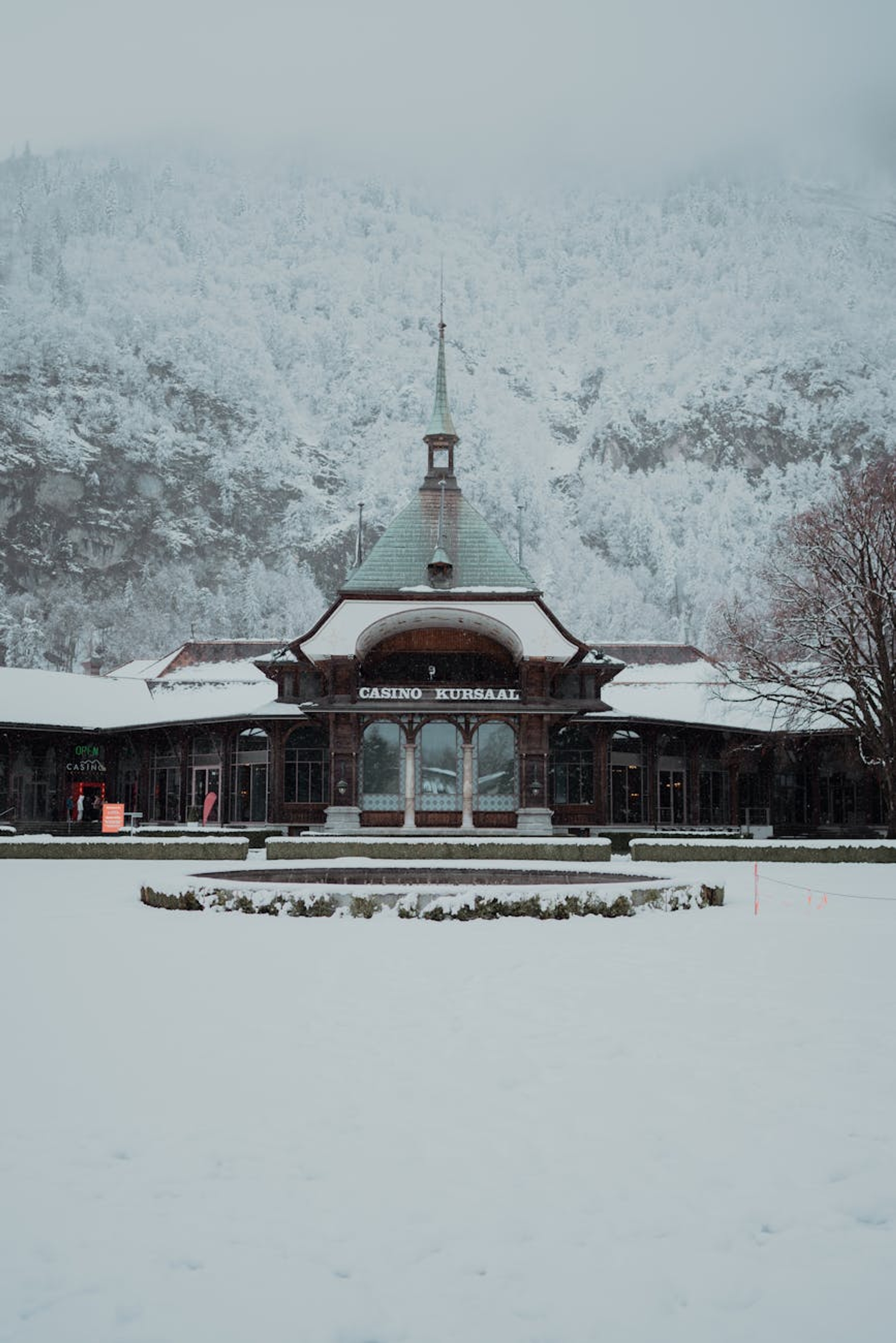 Snow-covered Casino Kursaal in Interlaken, Switzerland, surrounded by winter mountains