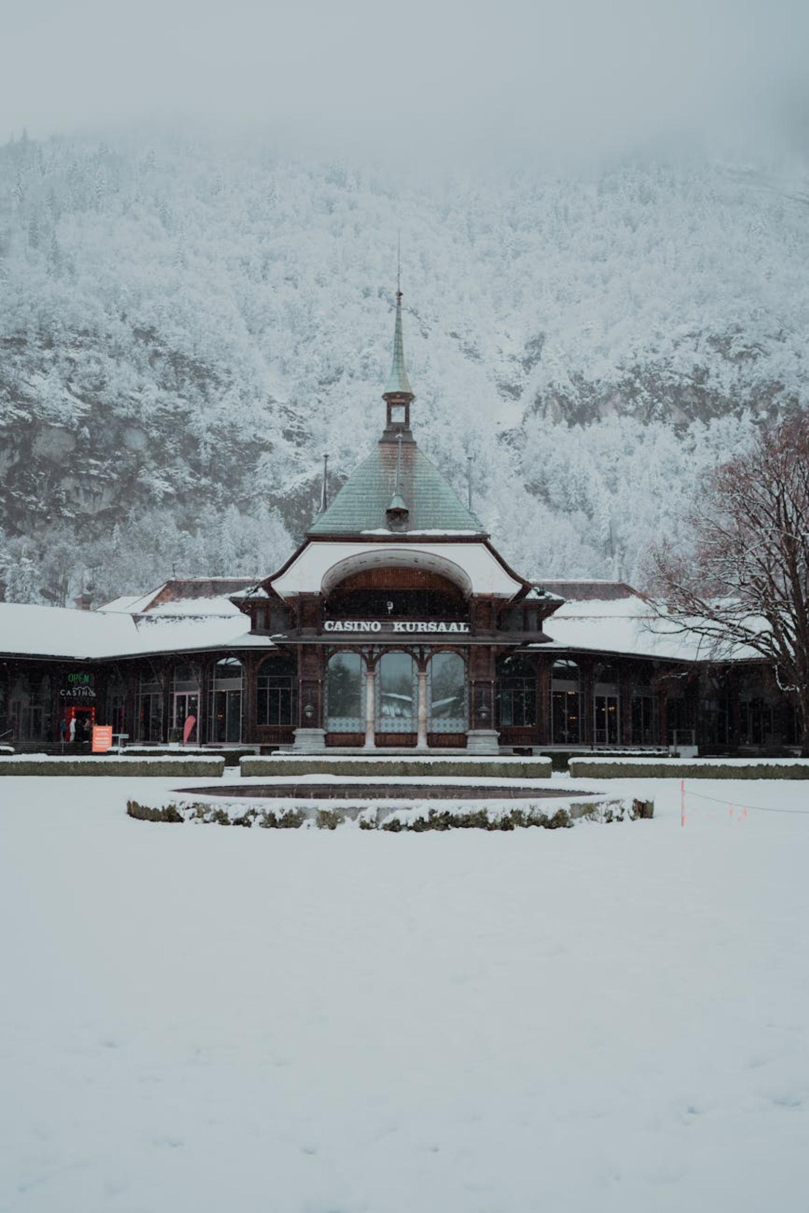 Snow-covered Casino Kursaal in Interlaken, Switzerland, surrounded by winter mountains
