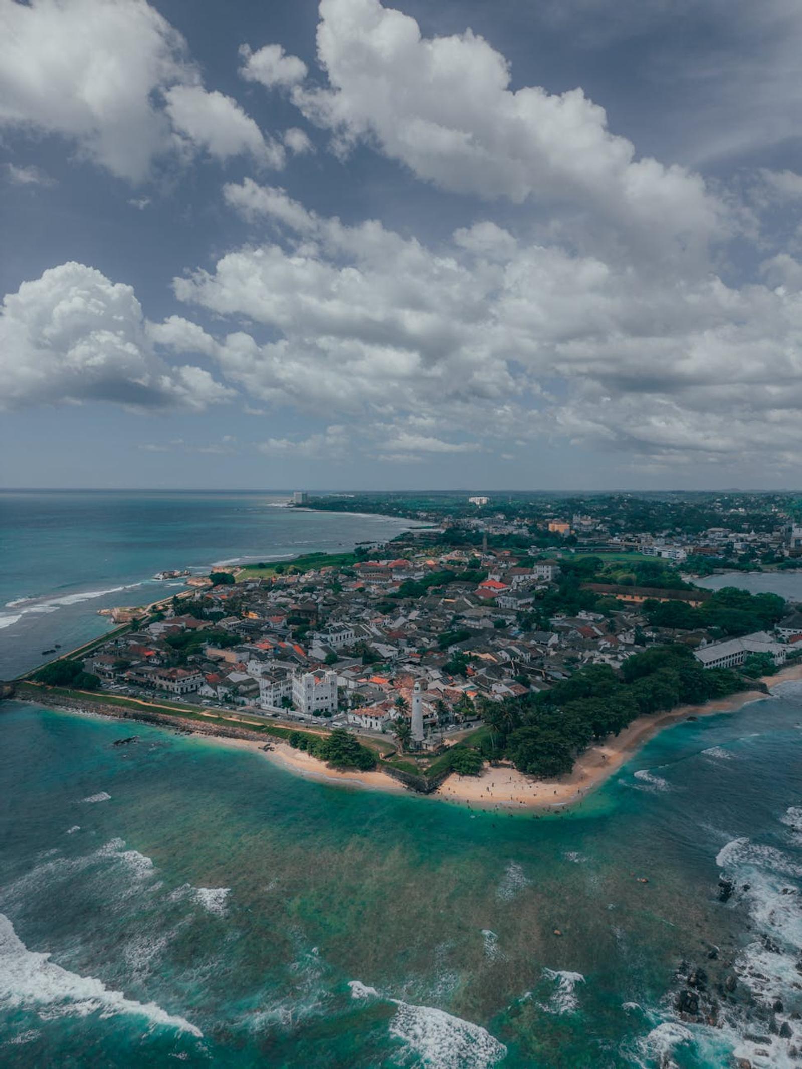 Aerial view of a fortified coastal peninsula town surrounded by turquoise sea