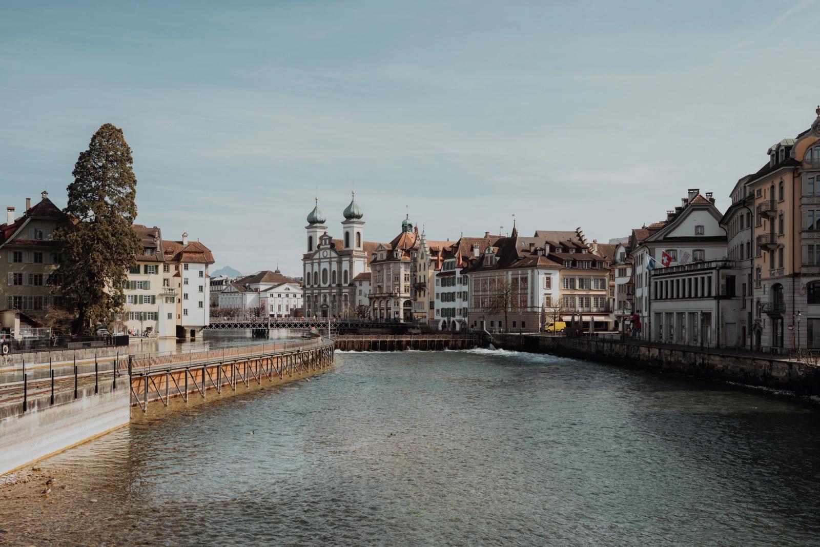 Charming view of Lucerne's iconic buildings alongside the Reuss river under a clear sky