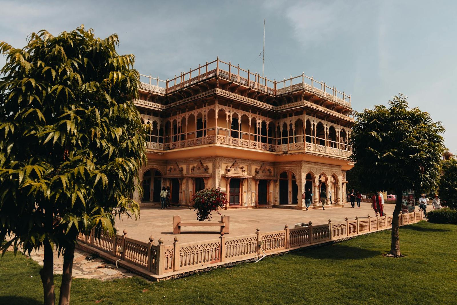 Two-storey ochre mansion with arched balconies set behind a garden