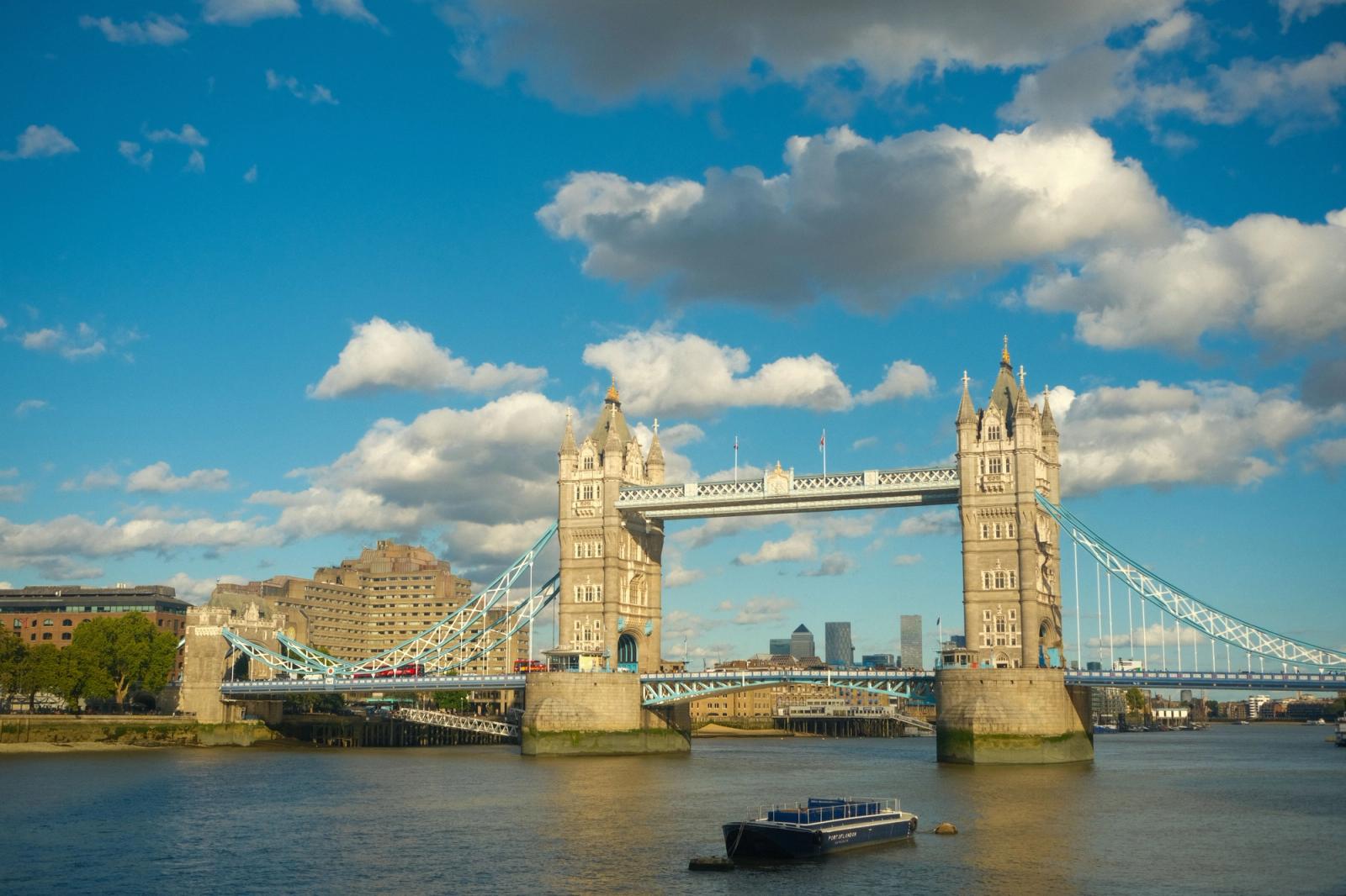 Breathtaking view of Tower Bridge, London, under a sunny blue sky with clouds