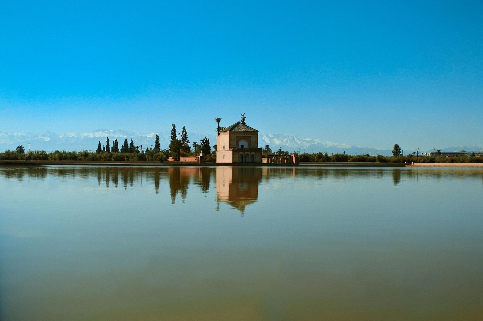 Domed pavilion reflected in a still garden pool with distant mountains behind
