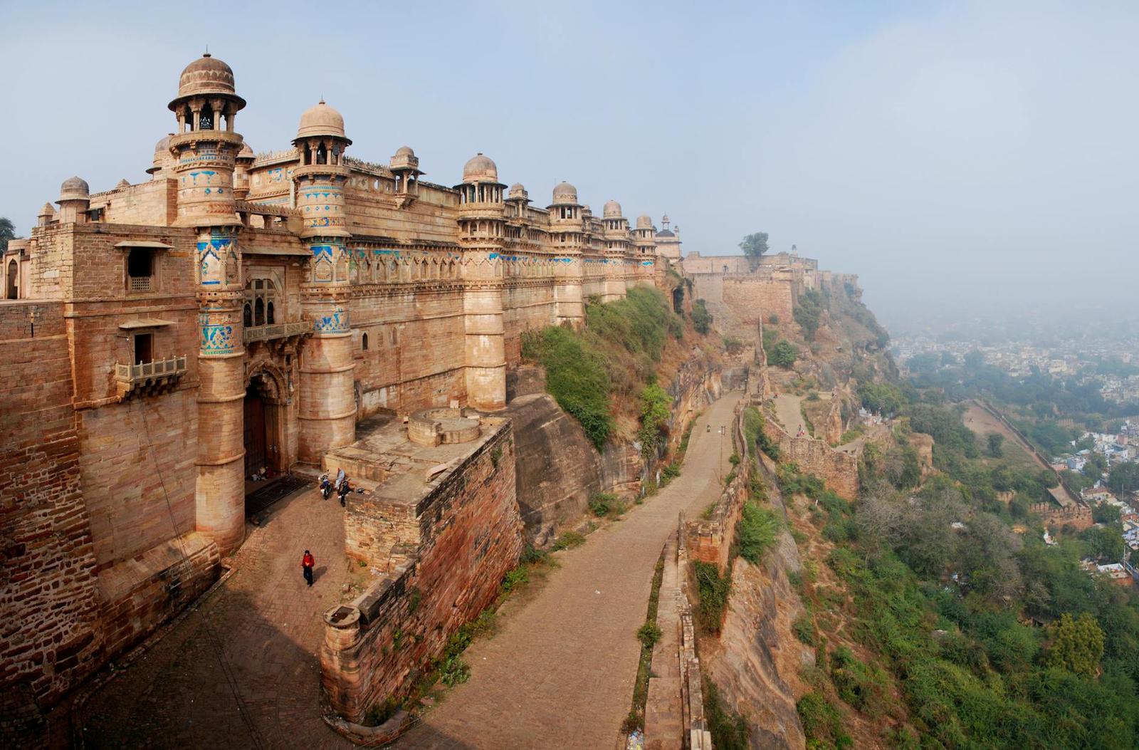 Long fortified wall winding along a cliff edge in hazy morning light