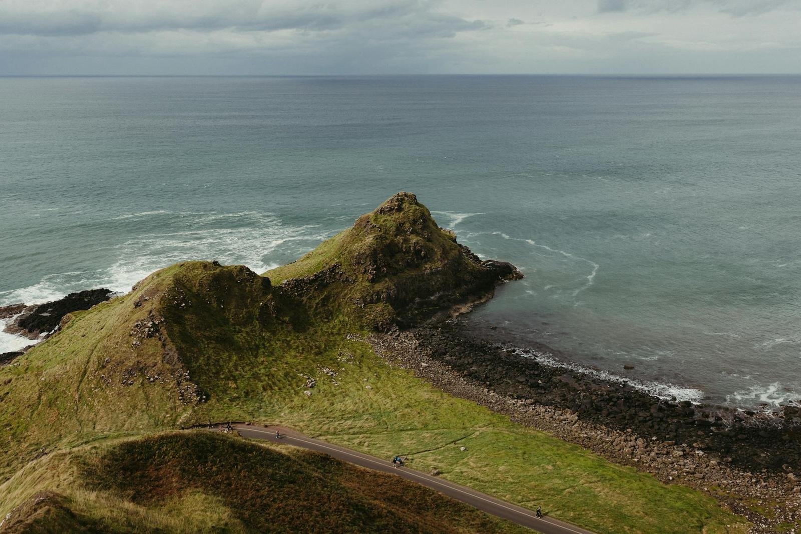 A grassy headland jutting into the sea along a rugged coastline