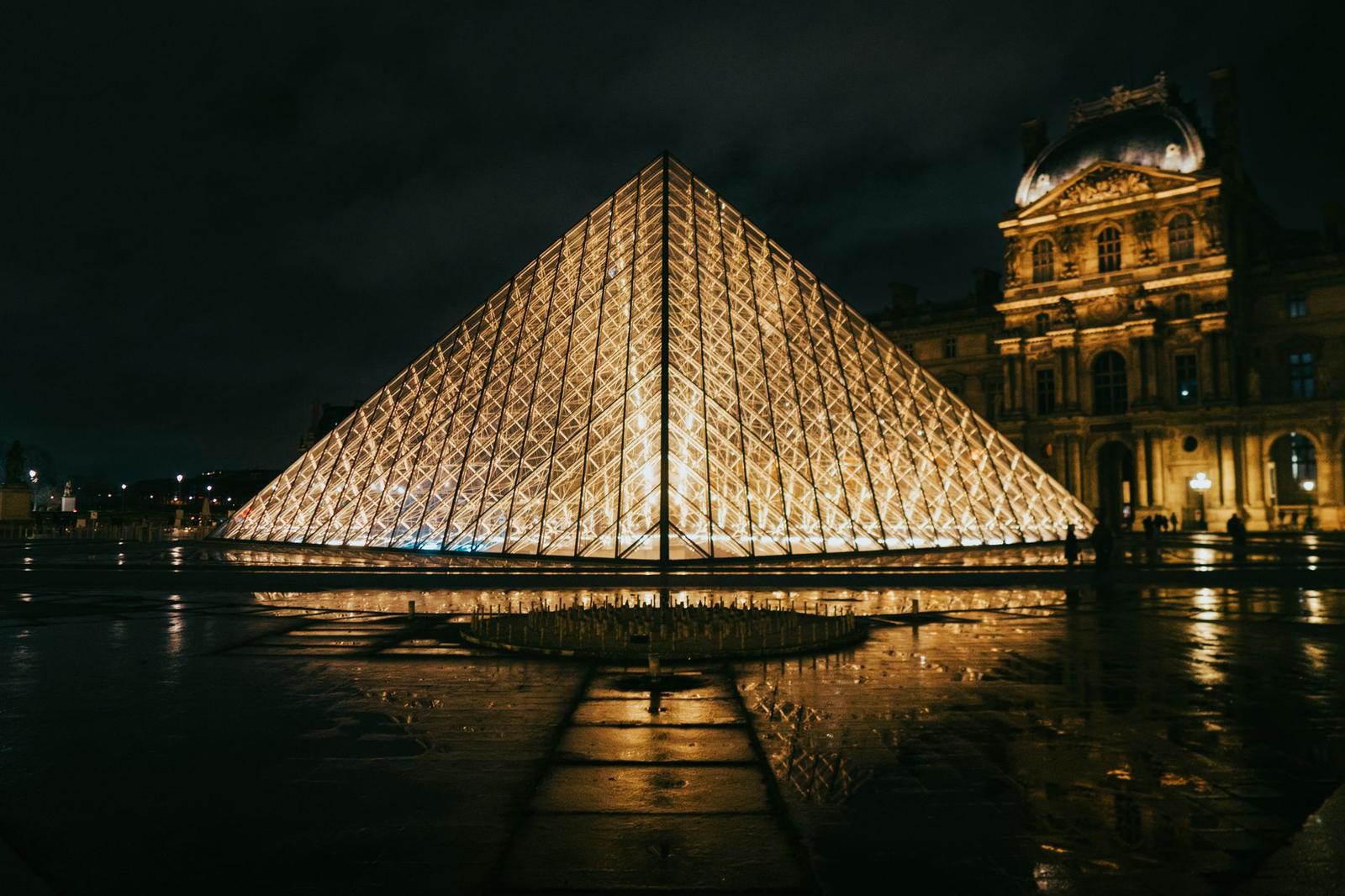 View of the Louvre Pyramid glowing at night