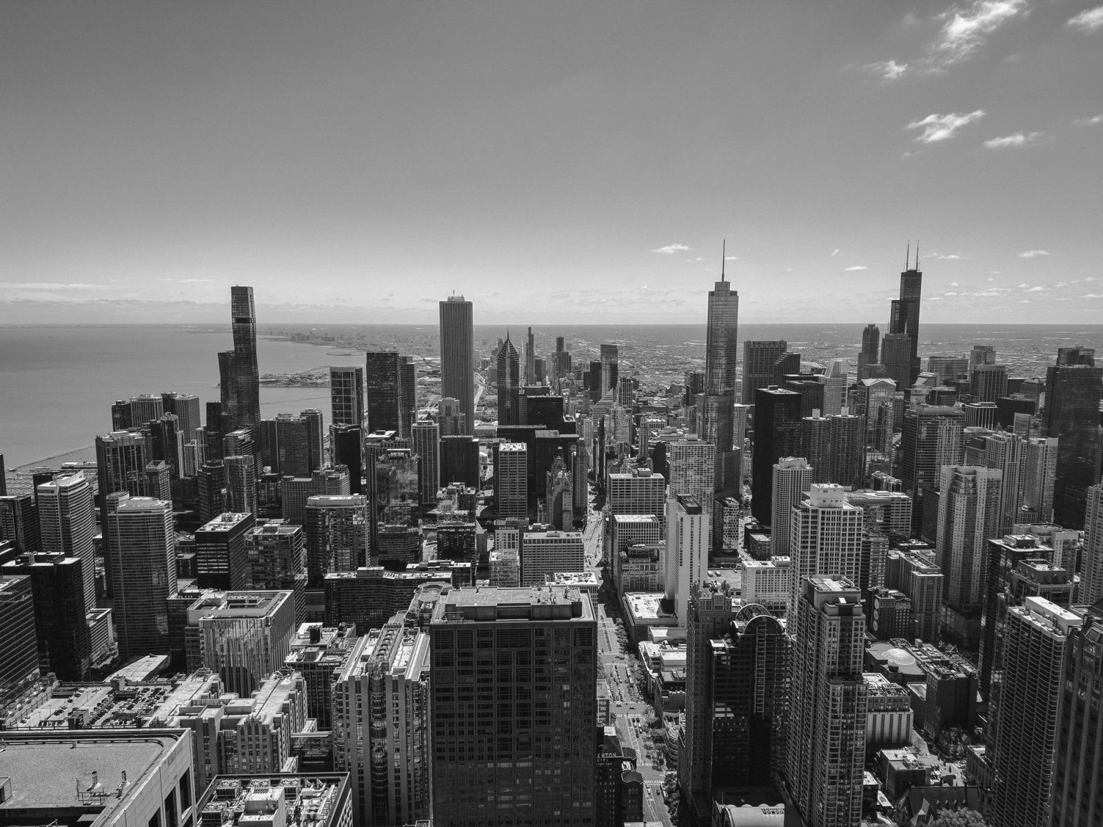 Dramatic black and white aerial view of Chicago, highlighting its iconic skyline and architecture