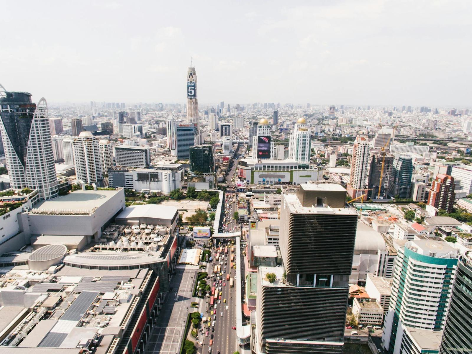 An aerial view of a dense city skyline with a tall tower and busy streets below