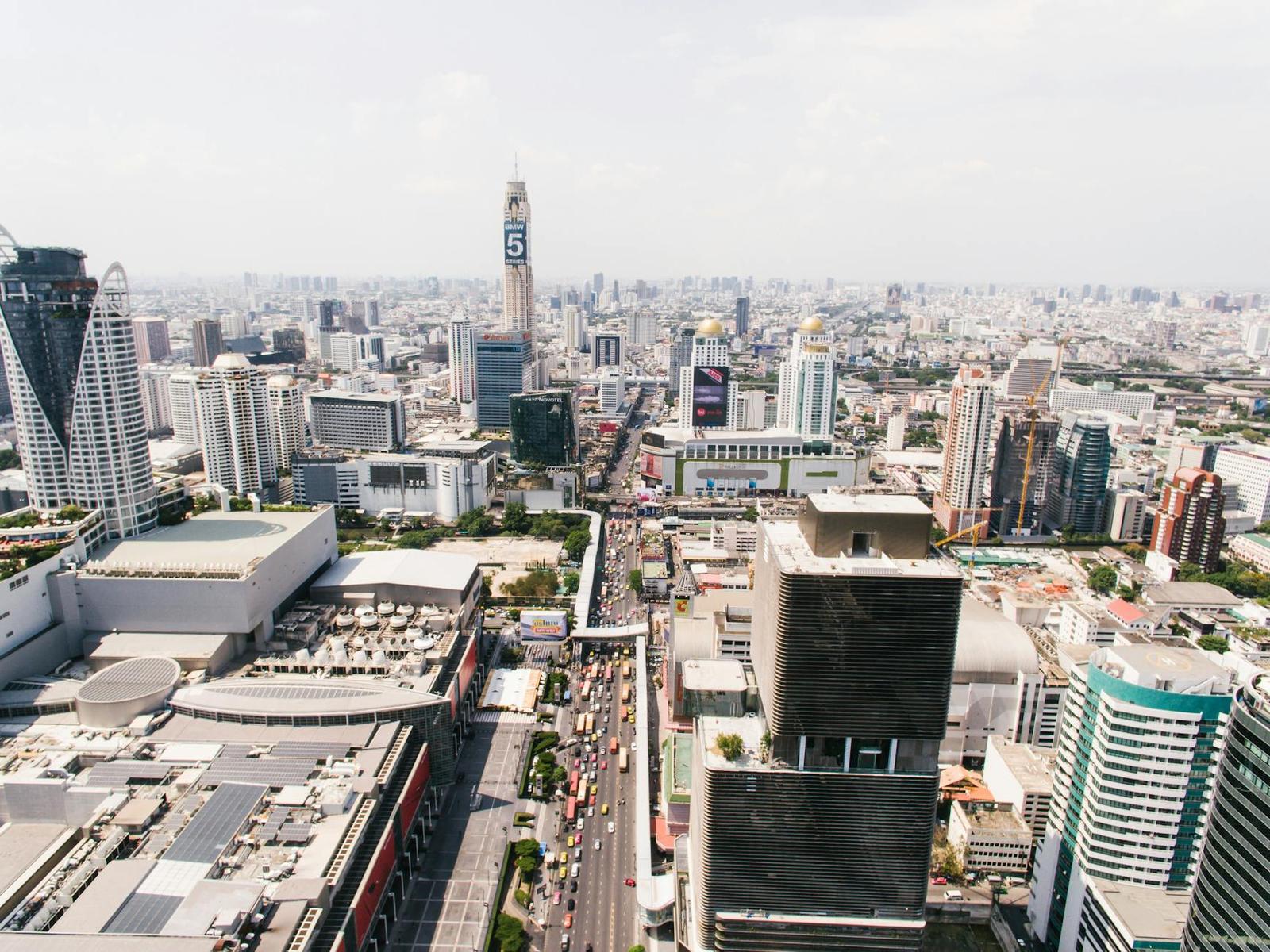 An aerial view of a dense city skyline with a tall tower and busy streets below
