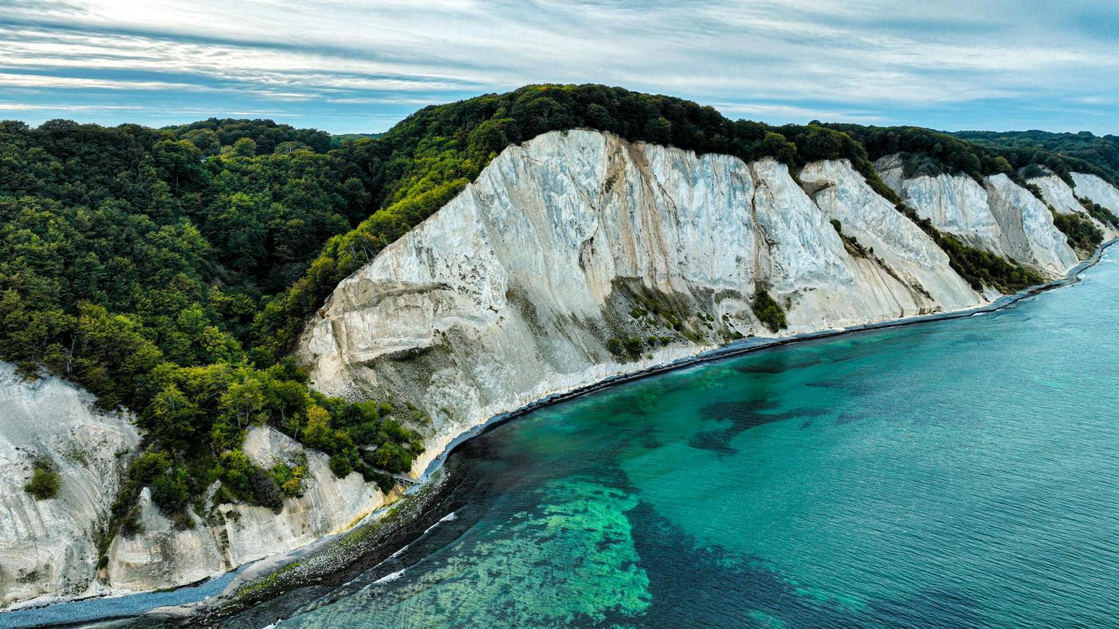 Aerial view of white chalk cliffs meeting turquoise sea