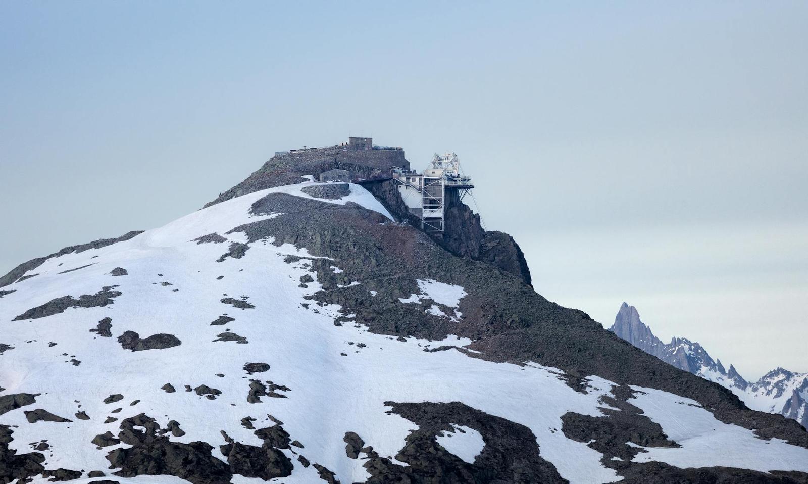 Snow-covered mountain peak with an observation structure