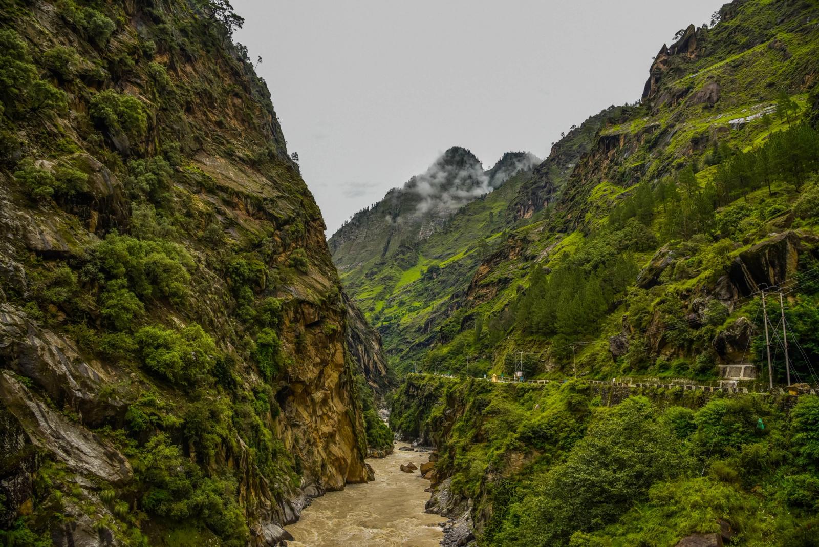 A breathtaking view of lush green mountains and a winding river in Himachal Pradesh, India
