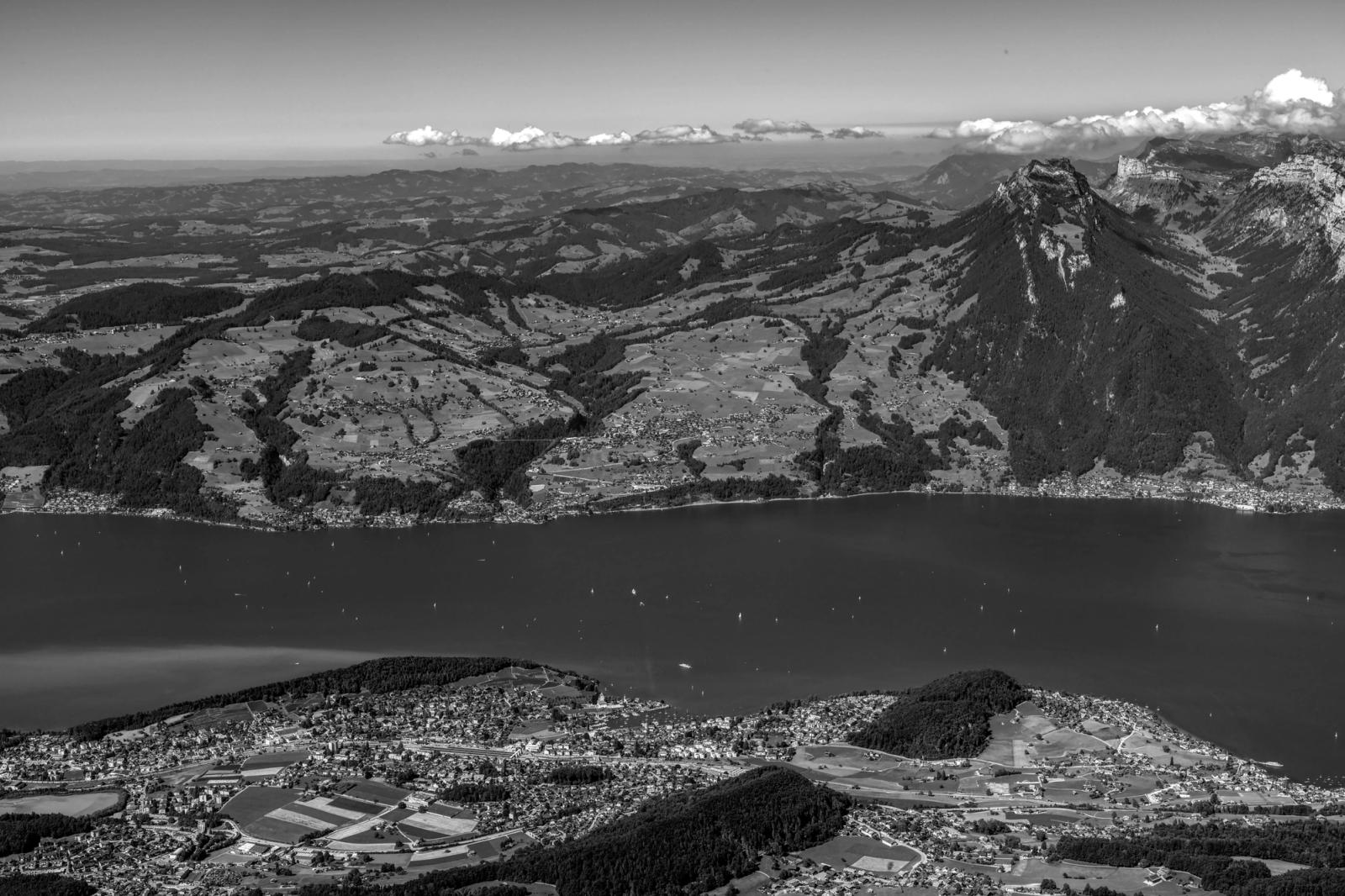 A scenic aerial shot of Lake Thun surrounded by mountains and valleys in Switzerland