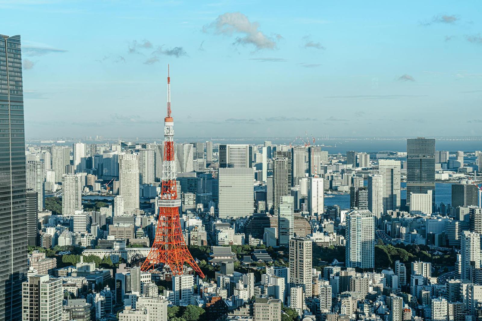 A red tower rising above a dense skyline under a clear blue sky