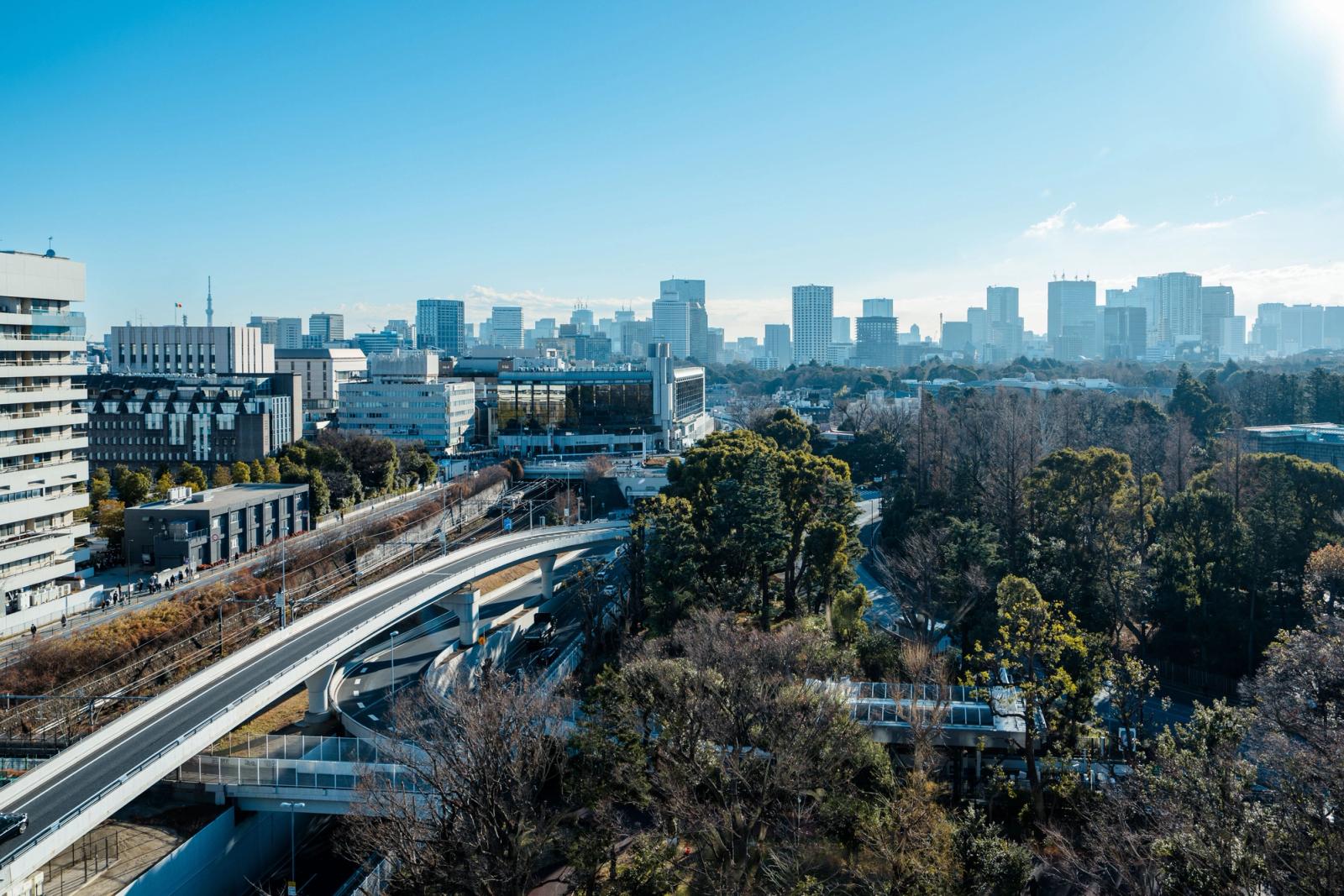Skyline of Tokyo featuring modern buildings and green urban spaces under a clear blue sky