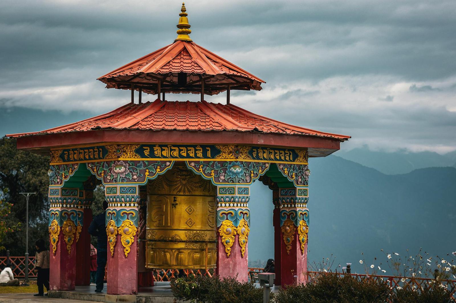 An ornate golden shrine pavilion with a red tiered roof