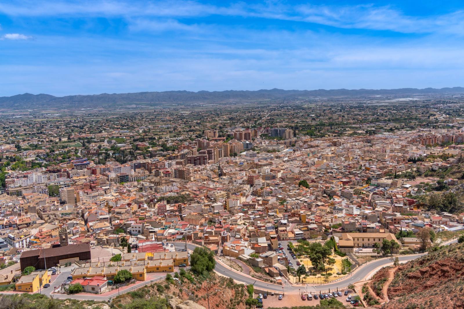 Aerial view of Lorca, Murcia, Spain showcasing the city's architecture and landscape under a clear blue sky