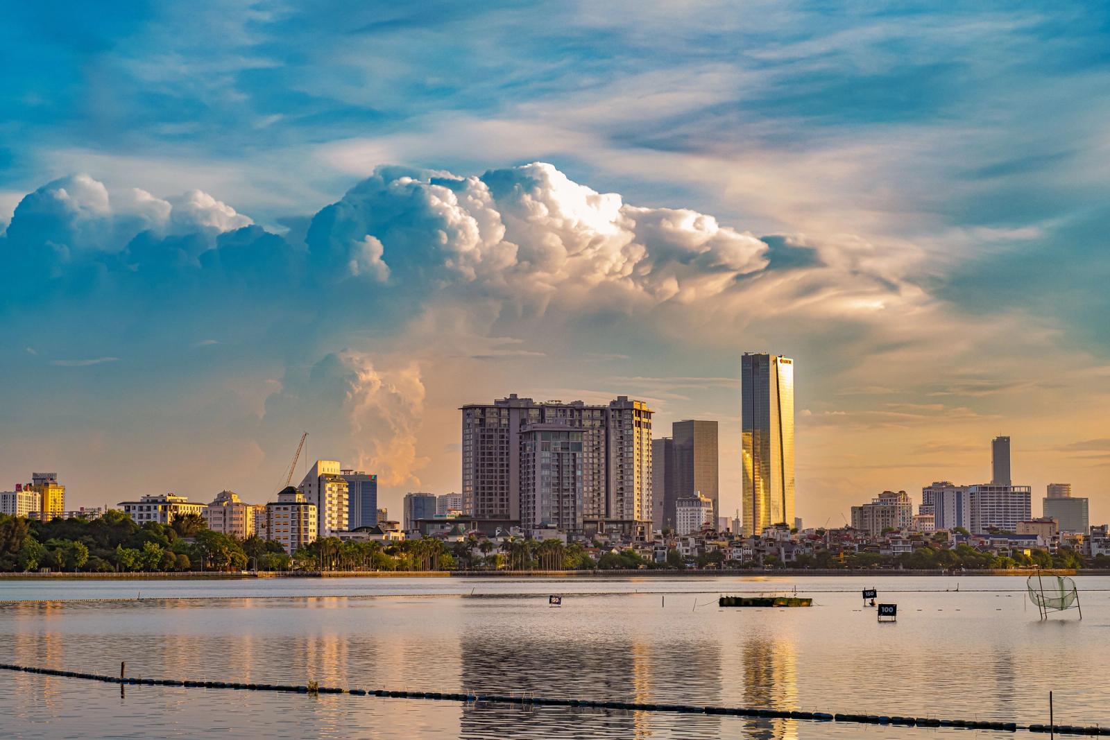 Vibrant sunset over Hanoi's skyline, reflecting beautifully on the calm river waters