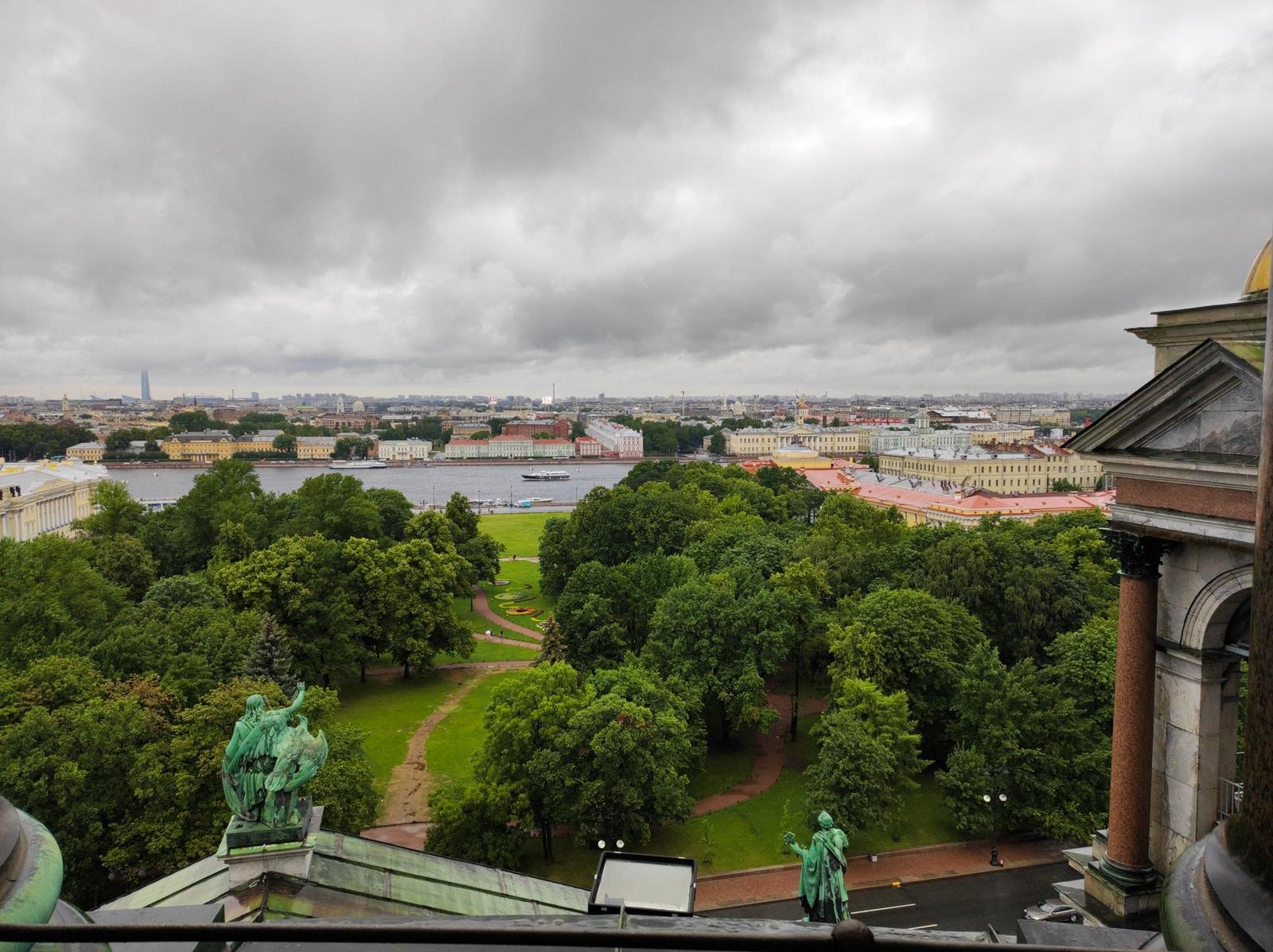 Cloudy skyline view over a green park and river from a rooftop terrace