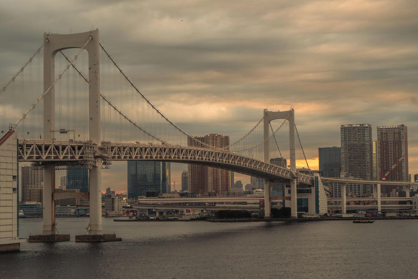 Scenic view of Tokyo's Rainbow Bridge at sunset with city skyline backdrop