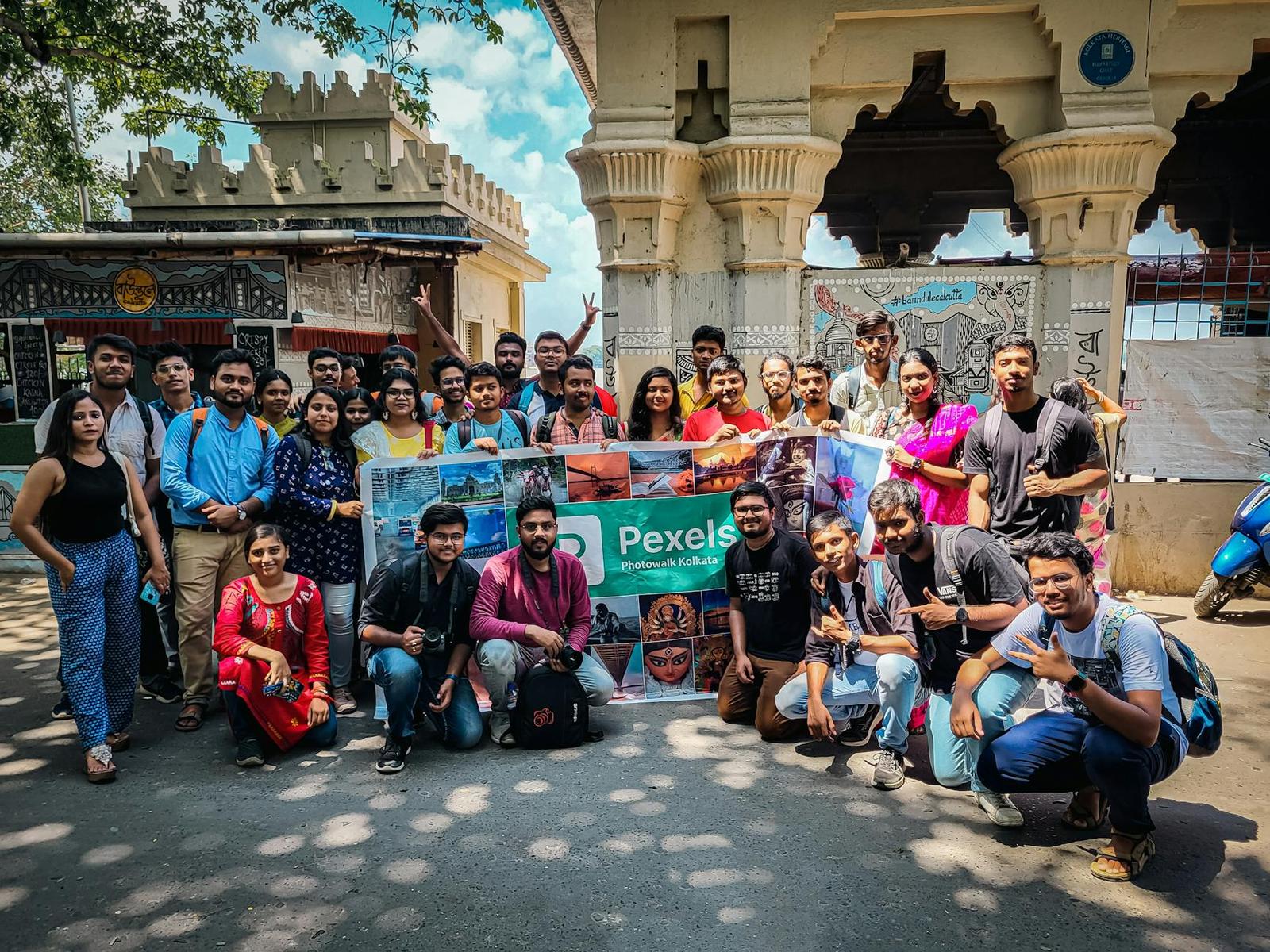 A large group of tourists posing together outside an ornate gateway
