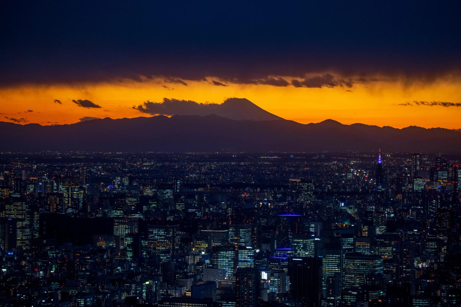 Breathtaking view of Tokyo skyline with Mount Fuji silhouetted against a vibrant sunset sky