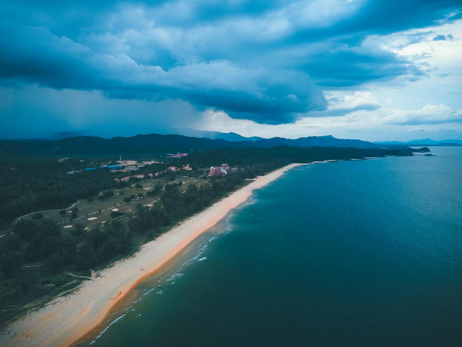 Aerial view of a resort-lined beach under an approaching storm