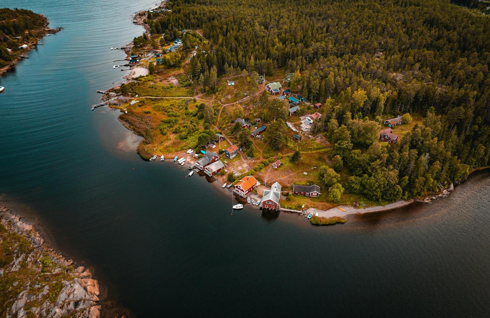 An aerial view of a wooded island with lakeside cabins