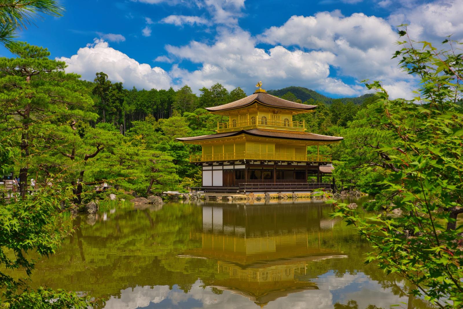 Stunning view of Kinkaku-ji temple reflecting in the pond on a sunny day in Kyoto, Japan