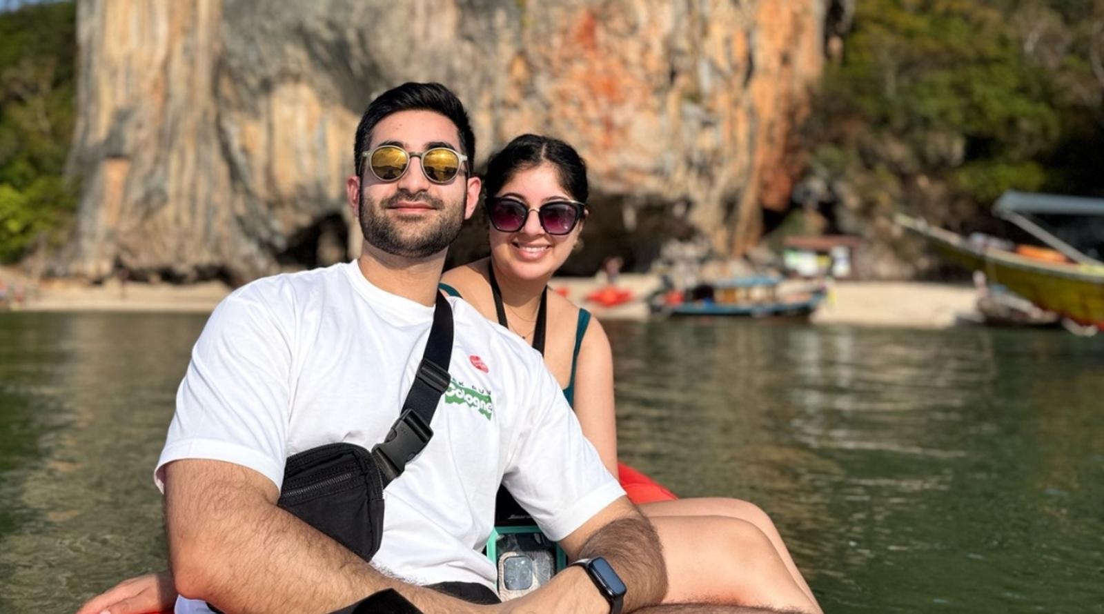 A couple sitting in a kayak on calm waters with a scenic