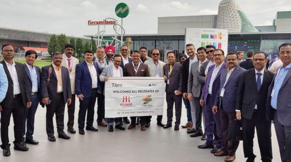 A group of delegates posing outdoors in front of a modern building