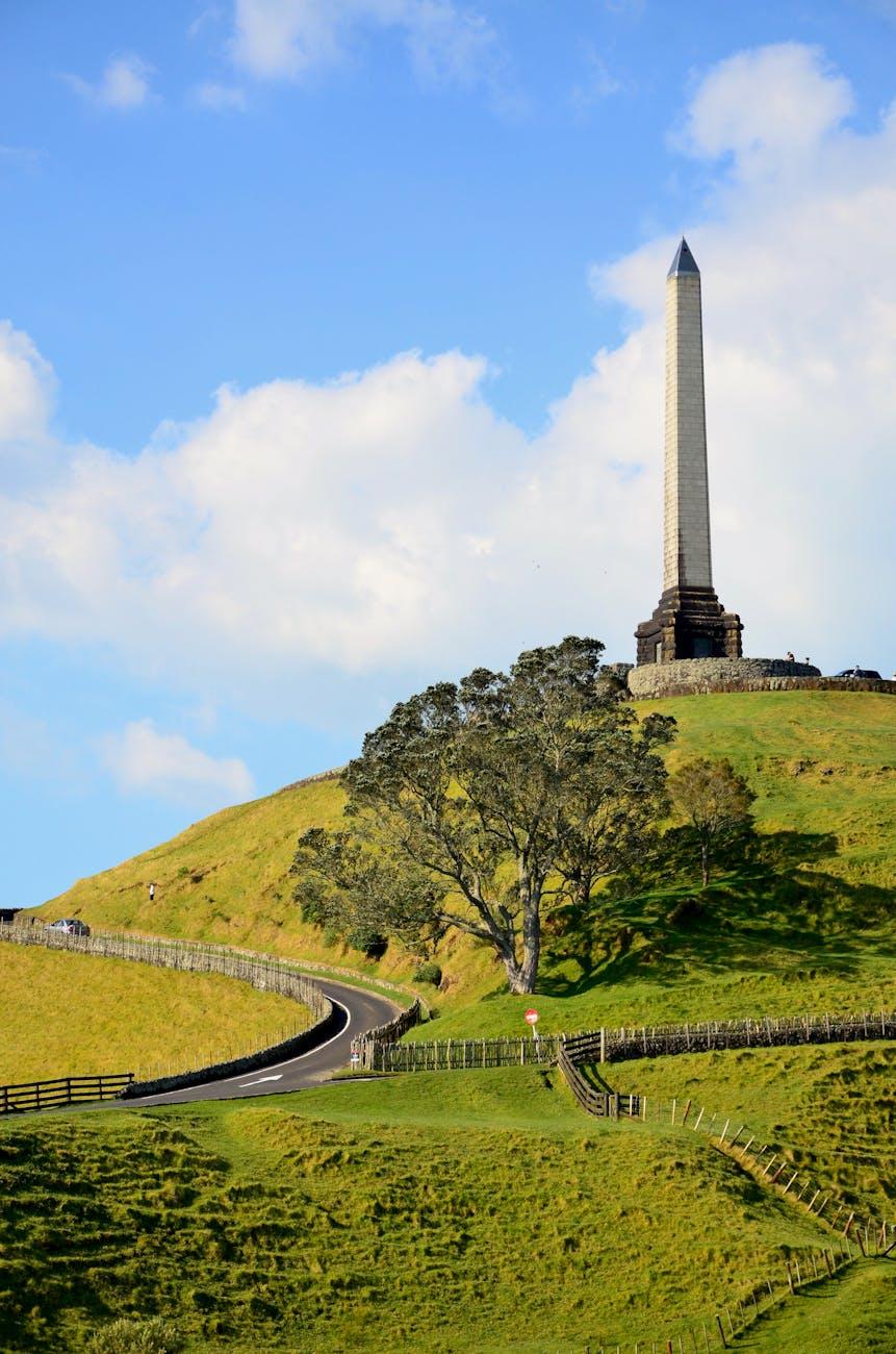 Beautiful view of One Tree Hill obelisk and green landscape under a blue sky in Auckland, New Zealand