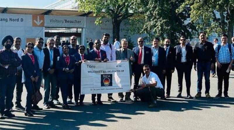 Group of people in formal attire posing outdoors in front of a building