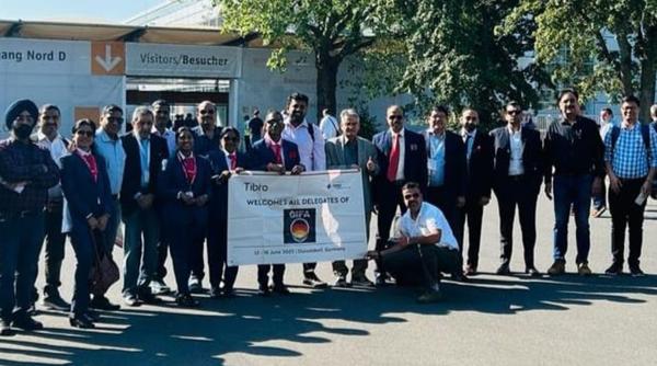 Group of people in formal attire posing outdoors in front of a building