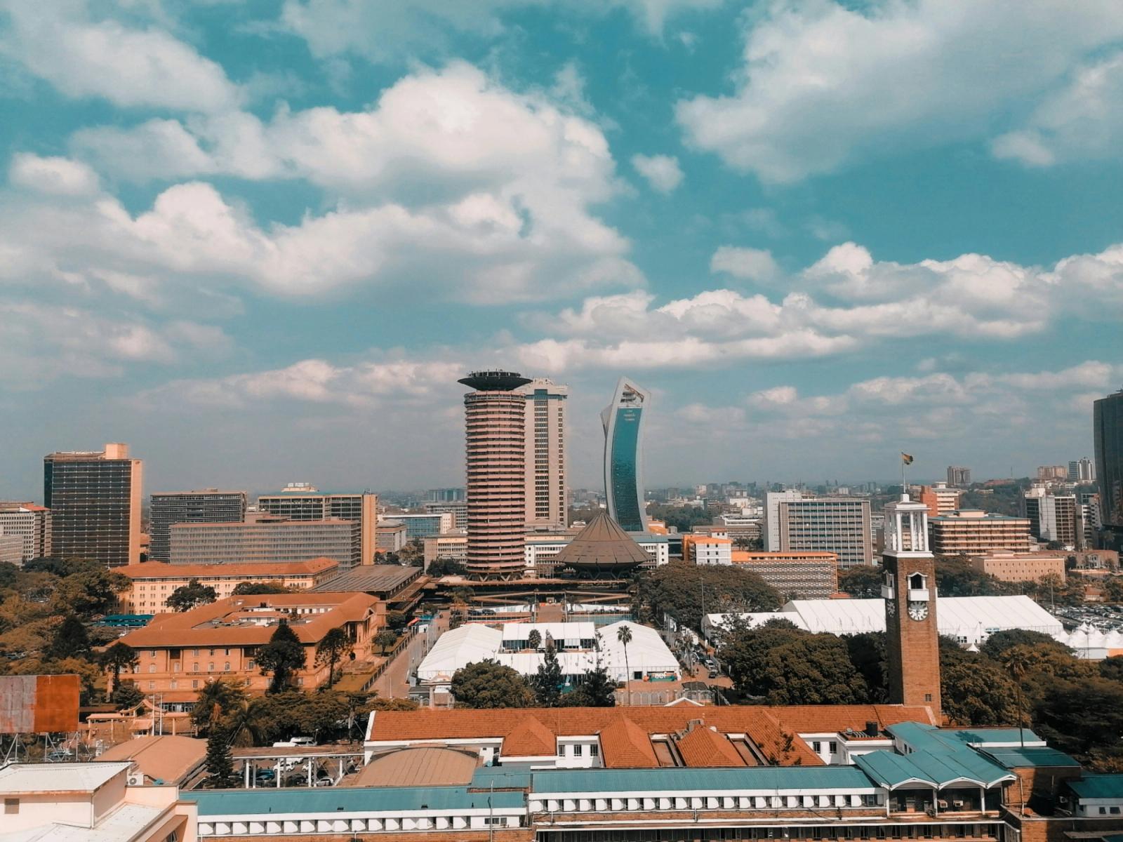 a view of a city with tall buildings A breathtaking view of Nairobi city's architecture and urban landscape. The photo captures the towering skyscrapers and modern buildings that make up the city's sk