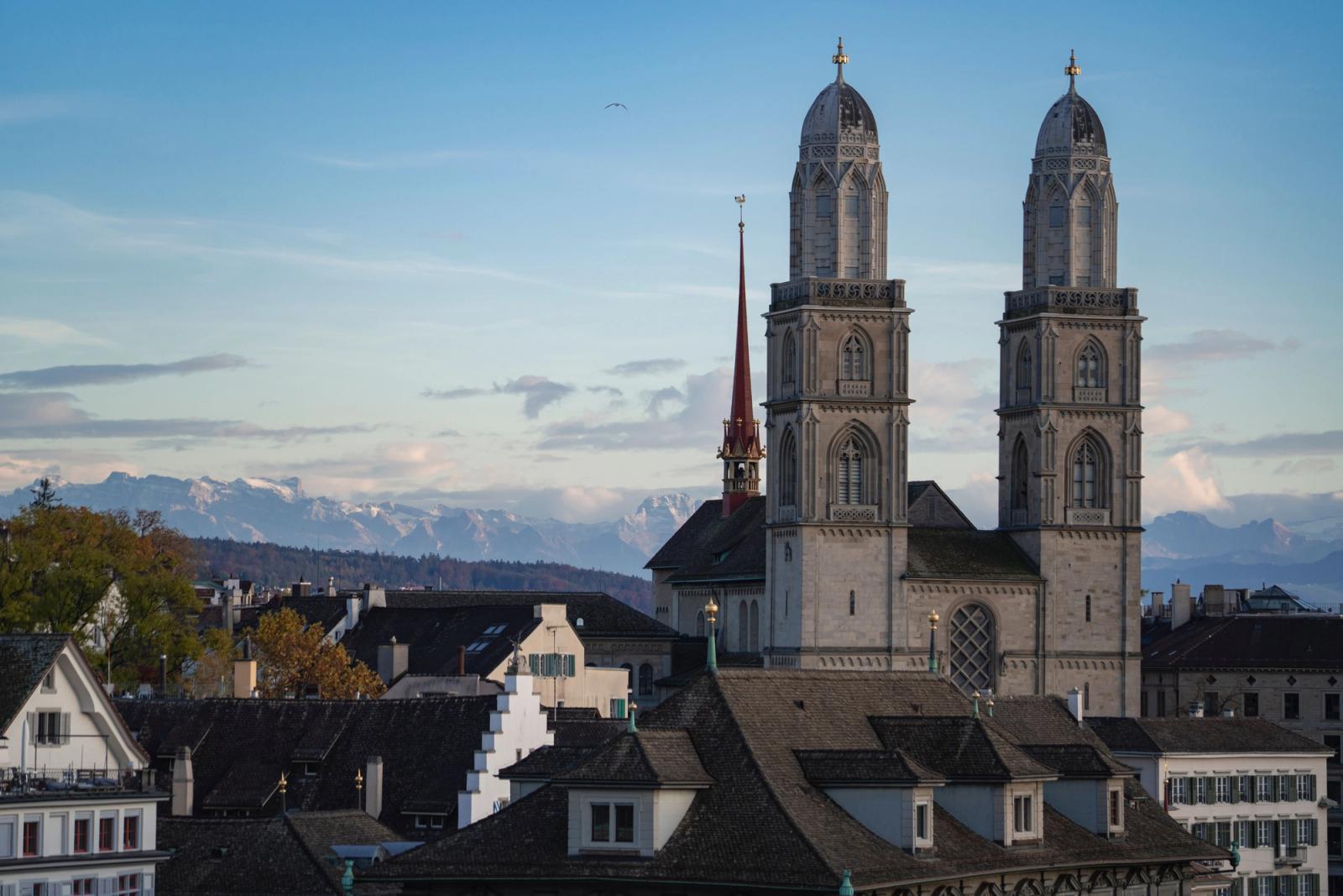 Capture of Grossmünster Church with Swiss Alps in Zurich during daytime