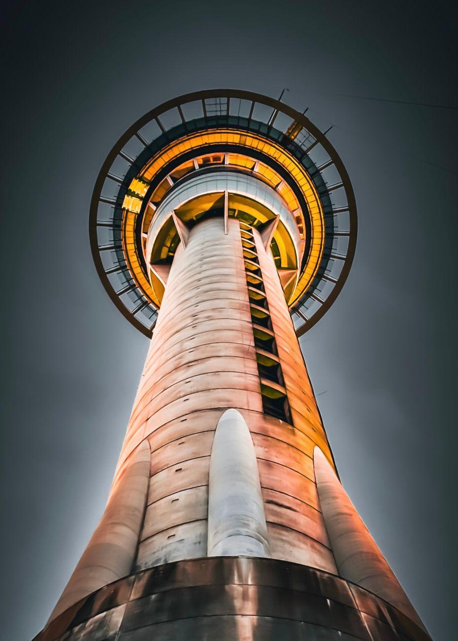 Dynamic low angle shot of Auckland's Sky Tower illuminated at night