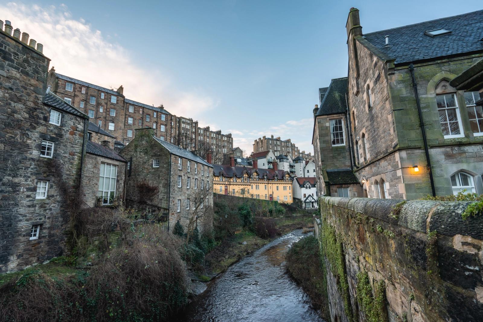 Charming view of Edinburgh's classic stone architecture by a peaceful river in Scotland