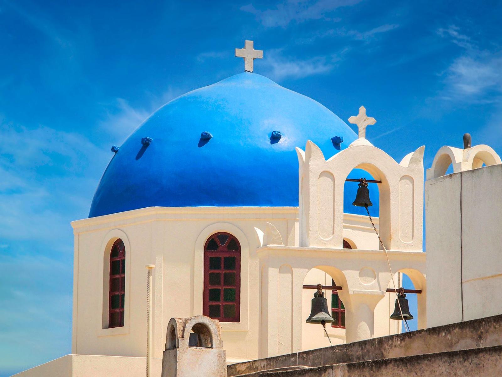 Captivating view of the Santorini blue dome church under a bright summer sky