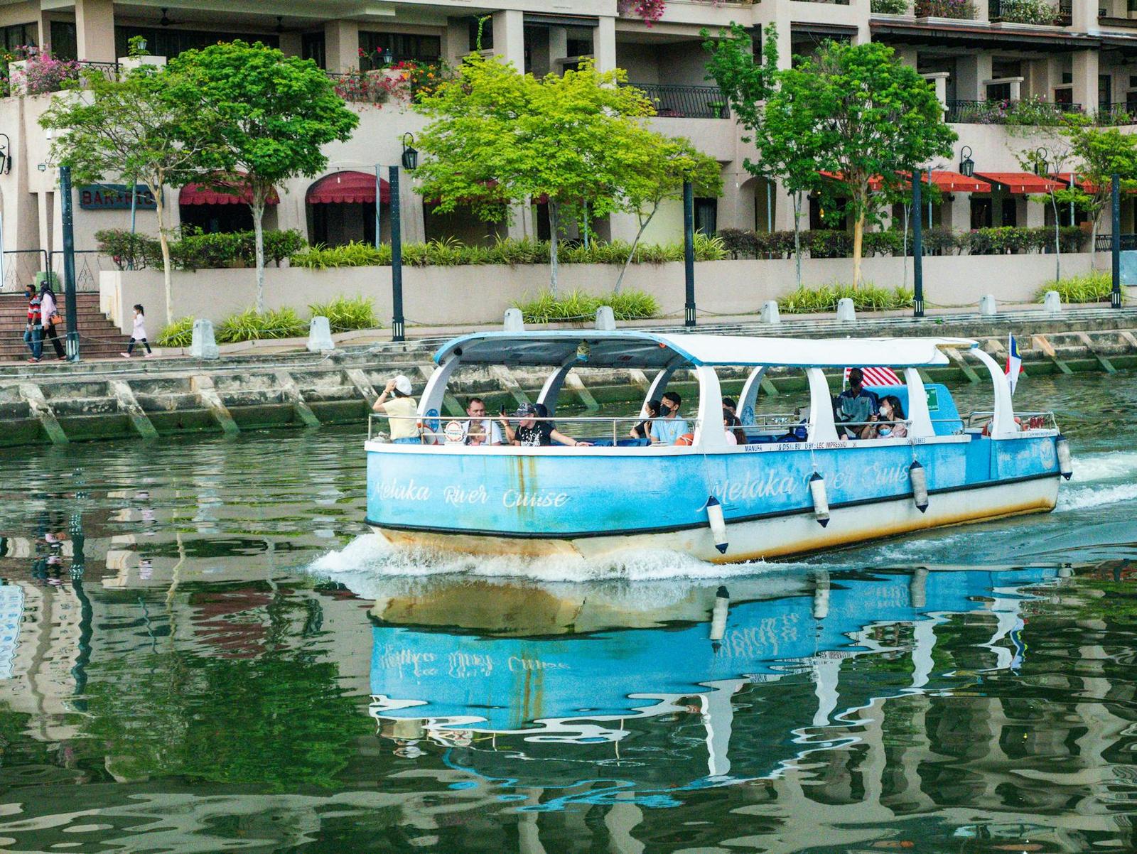 A tourist river cruise boat passing riverside apartment buildings
