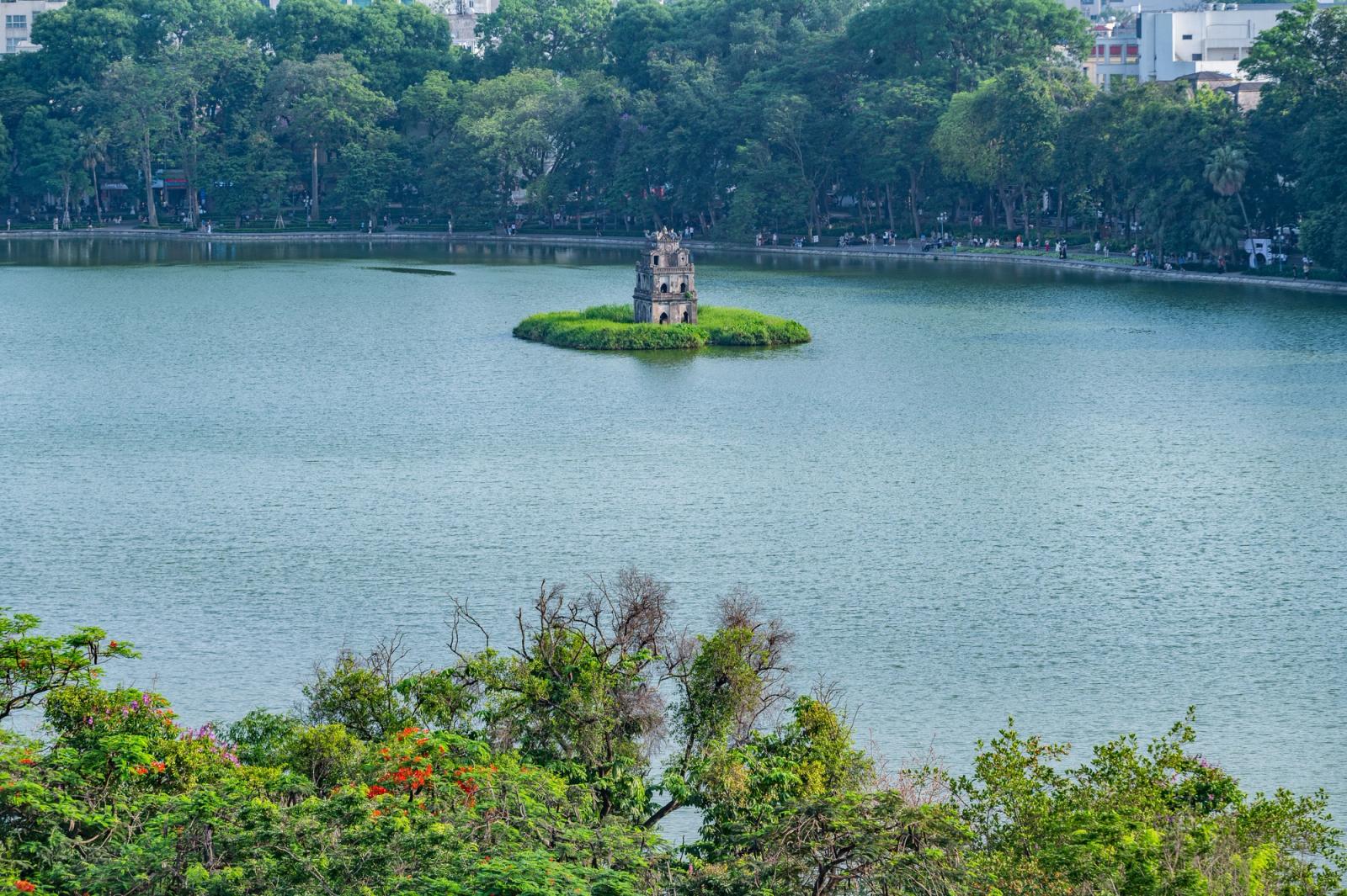 Small stone tower on a green islet in the middle of a lake