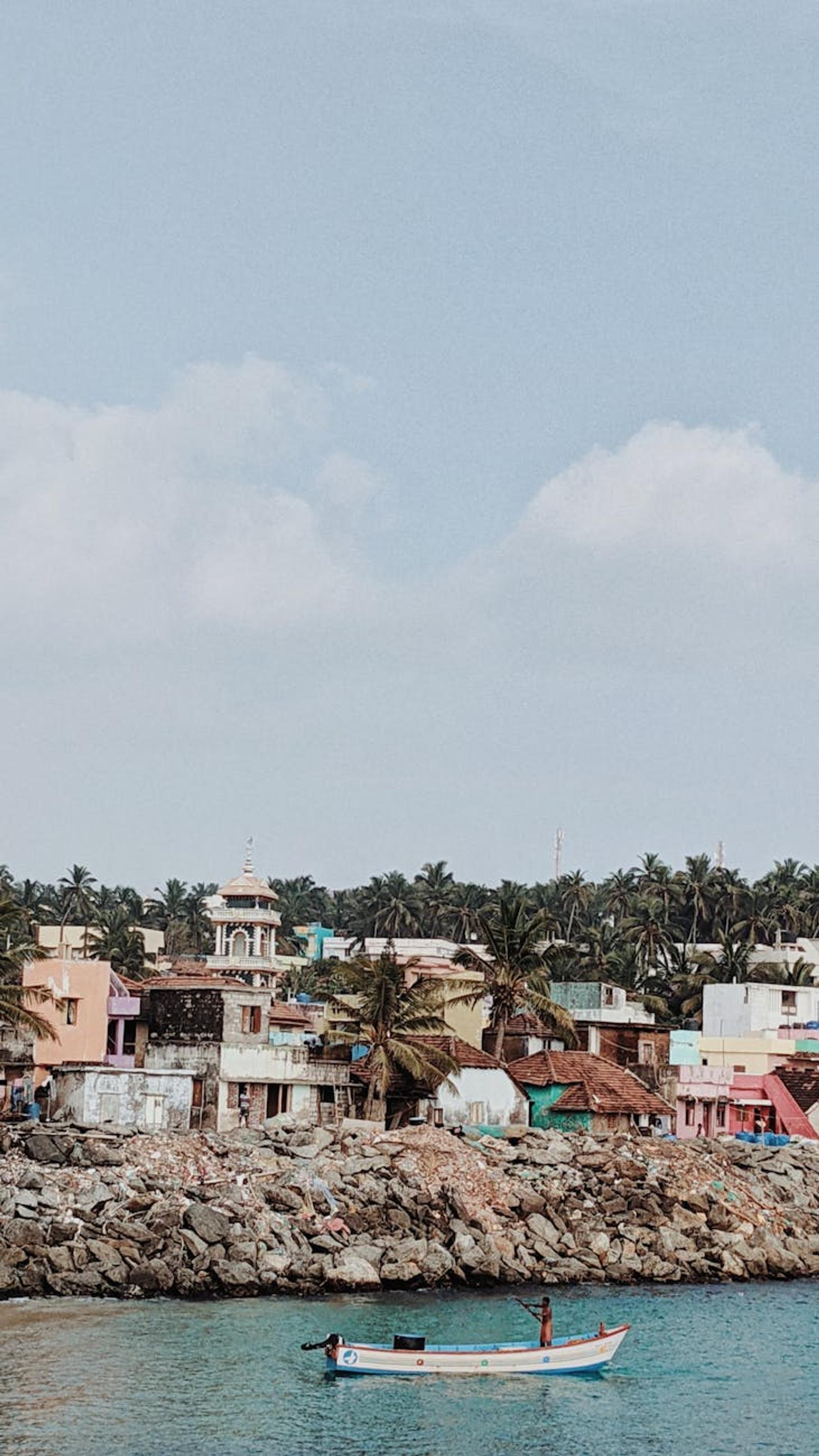 Charming coastal village with vibrant homes and a small boat in tranquil waters