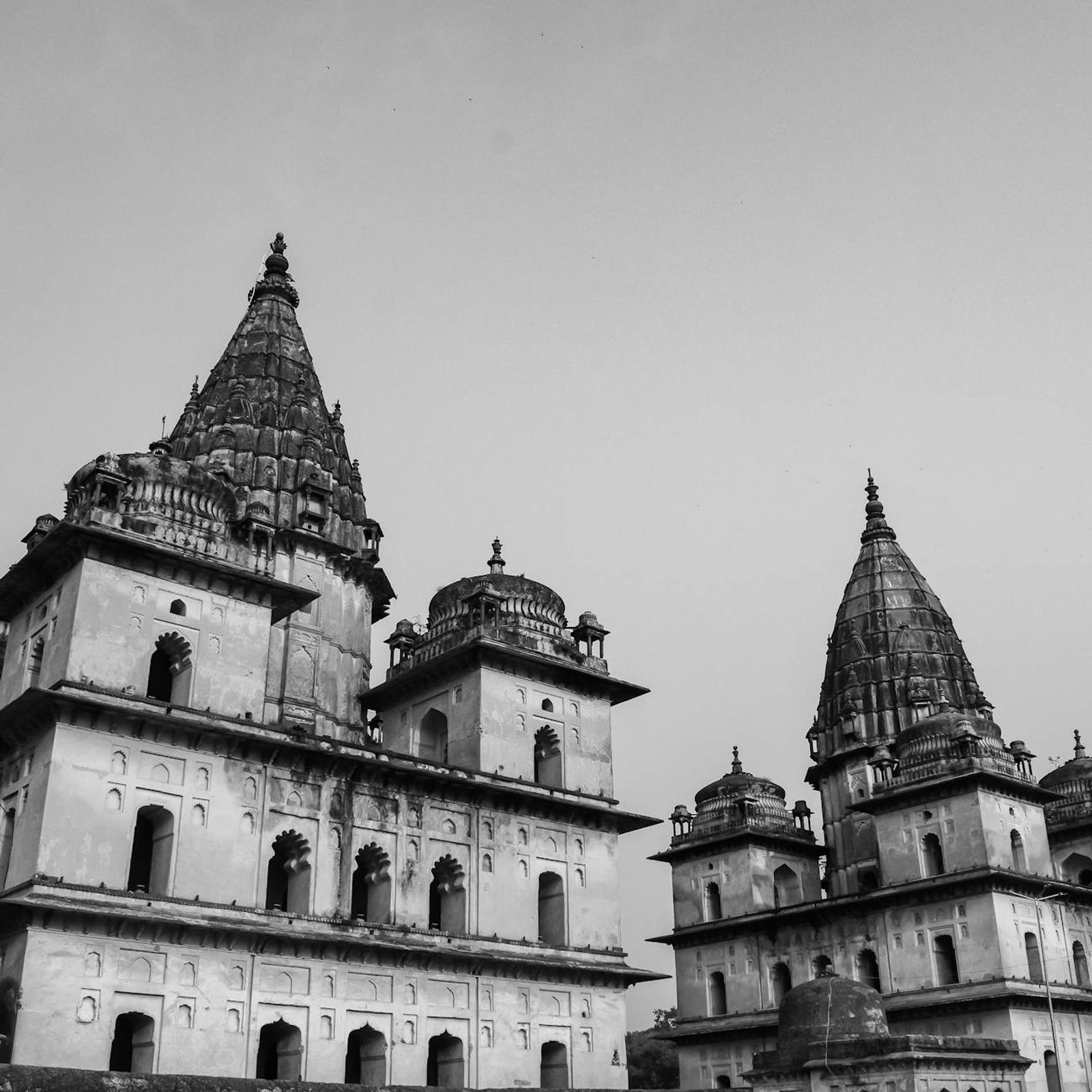 Black and white view of layered temple towers against an overcast sky