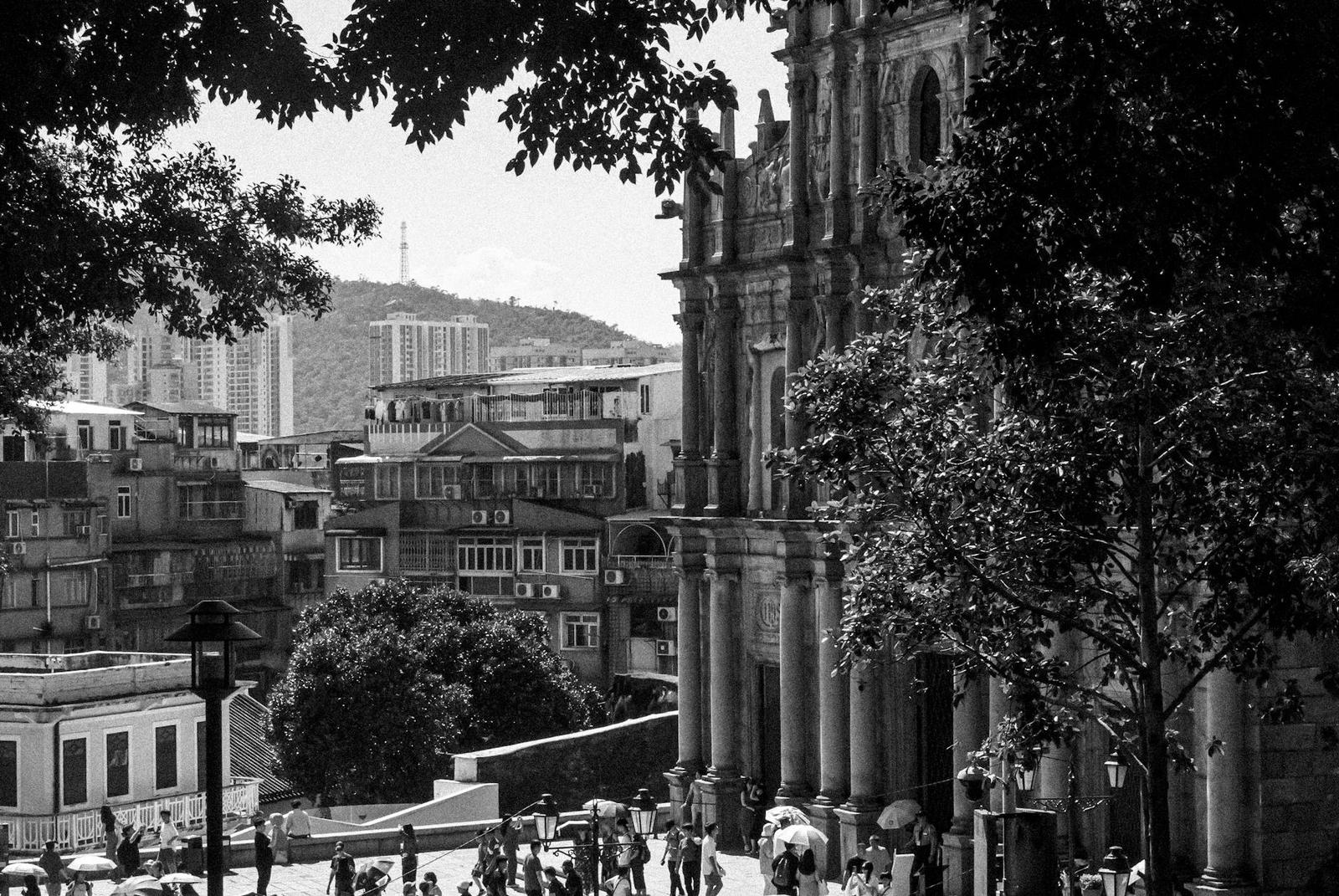 Black and white view of a baroque church facade above a hillside town square