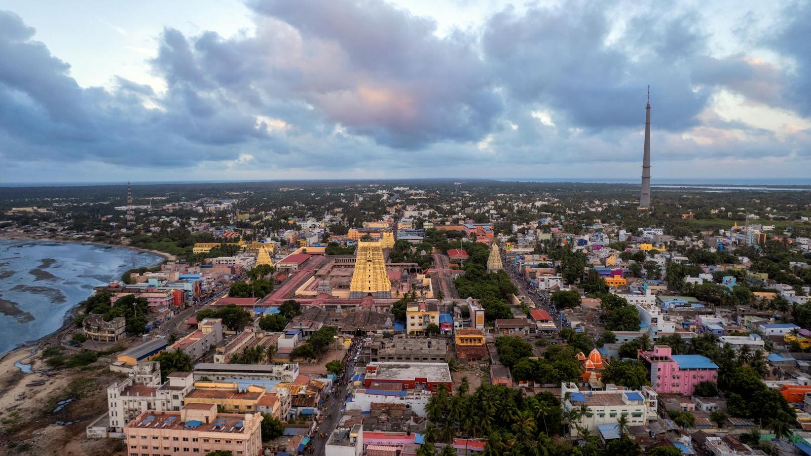 Aerial view of a coastal temple town under a cloudy dusk sky